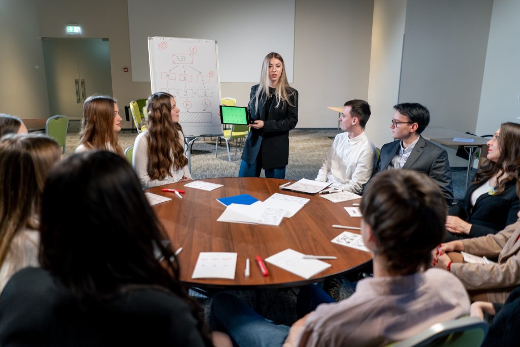 the manager holds a tablet with a green screen in his hands tells his colleagues about the development plan for the company